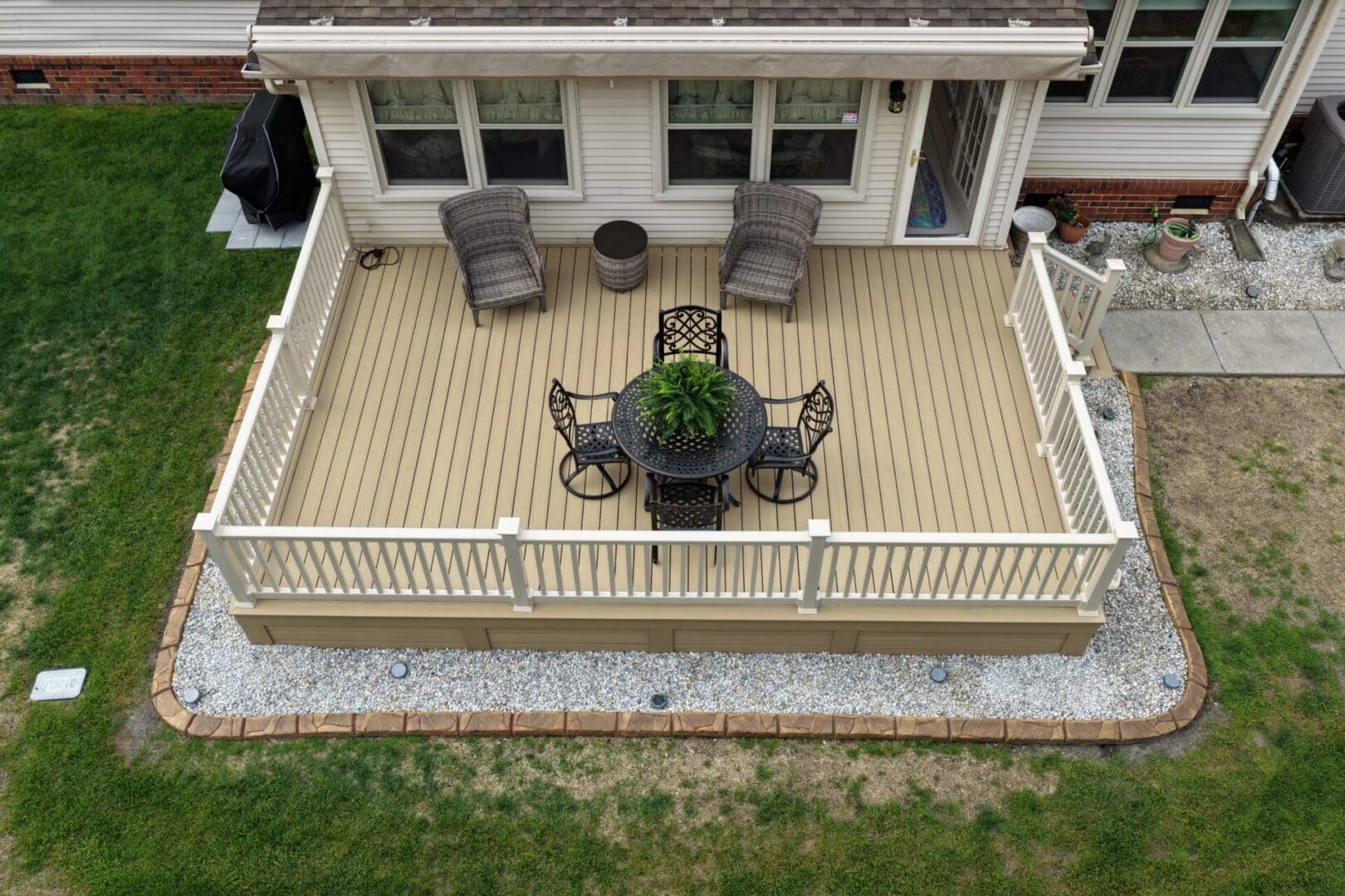 Completed Williamsburg Trex deck renovation with white railing and horizontal skirting