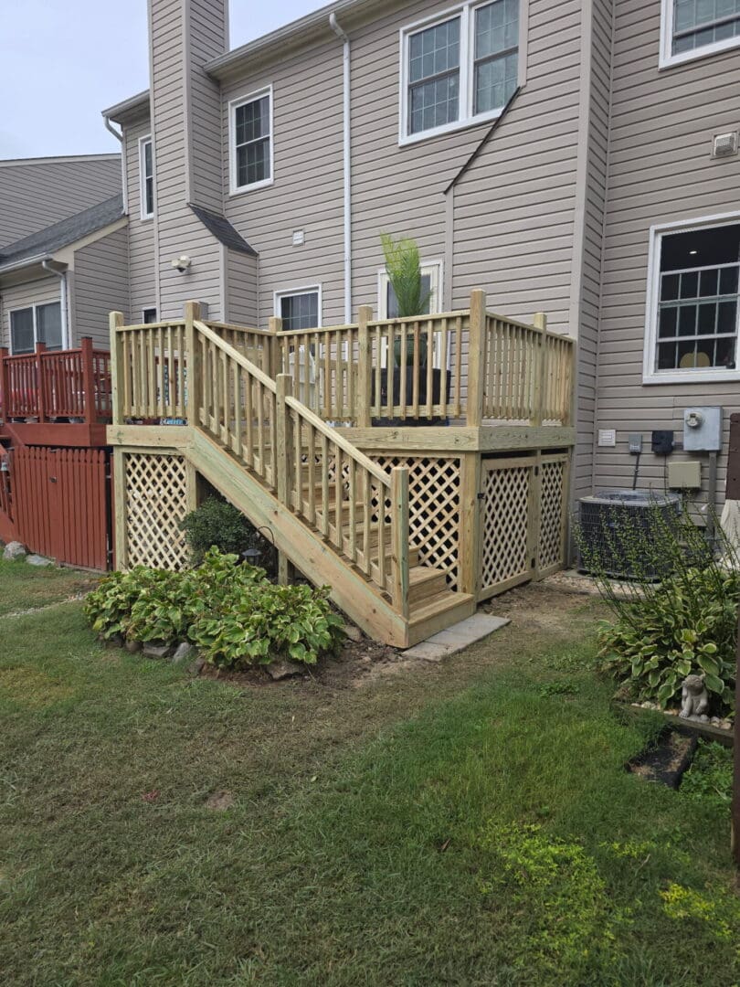 Completed pressure-treated wood deck replacement with new stairs and railing in Virginia Beach
